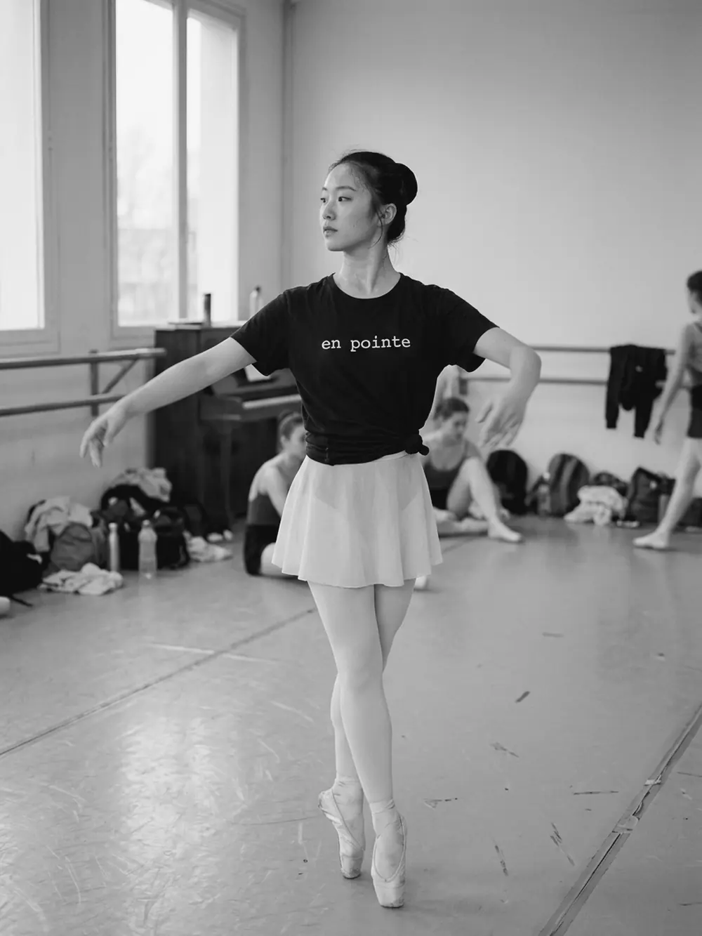 Bailarina de puntas en la sala de ballet, con la camiseta negra en pointe anudada